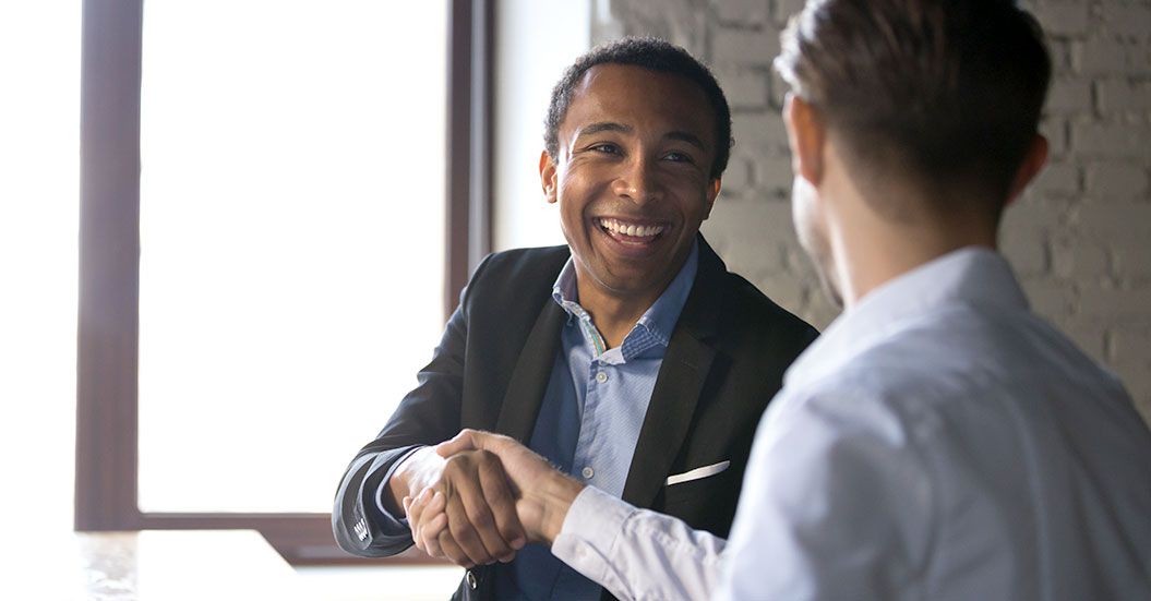 African American sales rep shaking hands with a client.