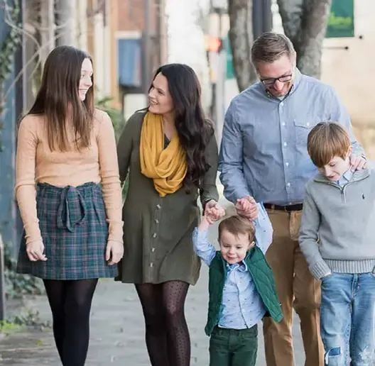 A family walking down the sidewalk.