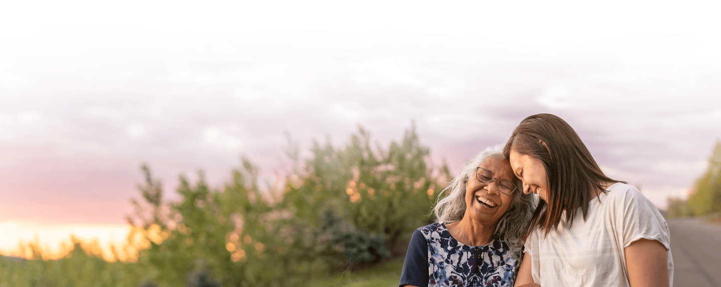 A mother and daughter smiling in the sunset