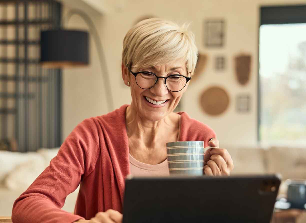 An elderly woman does some research on her computer
