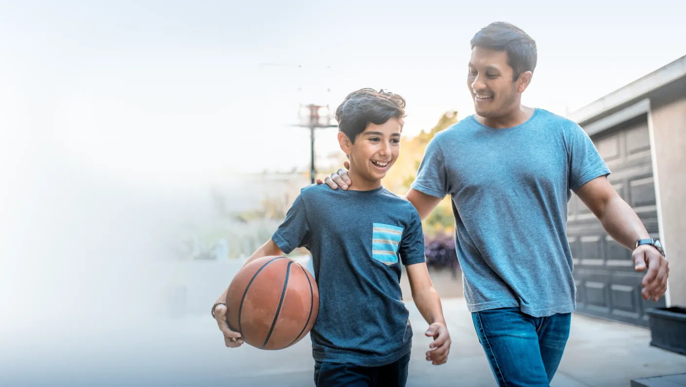 A man and his son playing basketball.