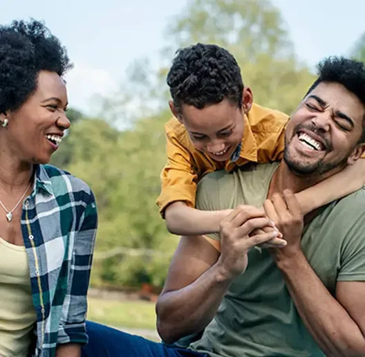 A family laughing and playing outside.